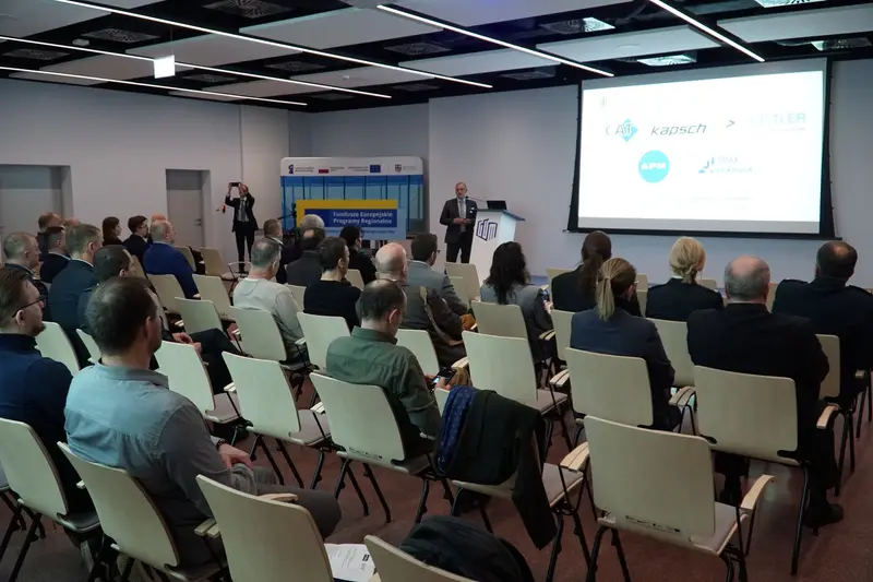 View of the seminar room during a presentation; project partners' logos shown on screen.